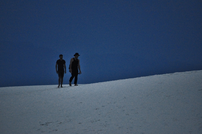 people walking across sand